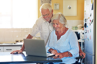 Buy stock photo Elderly, couple and smile with laptop in kitchen for internet, website and reading elections results. Home, senior man and woman with technology on table for political, registration and online news