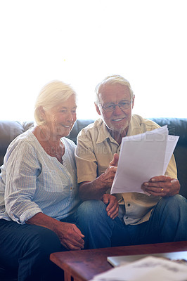 Buy stock photo Shot of a senior couple going through their paperwork together at home