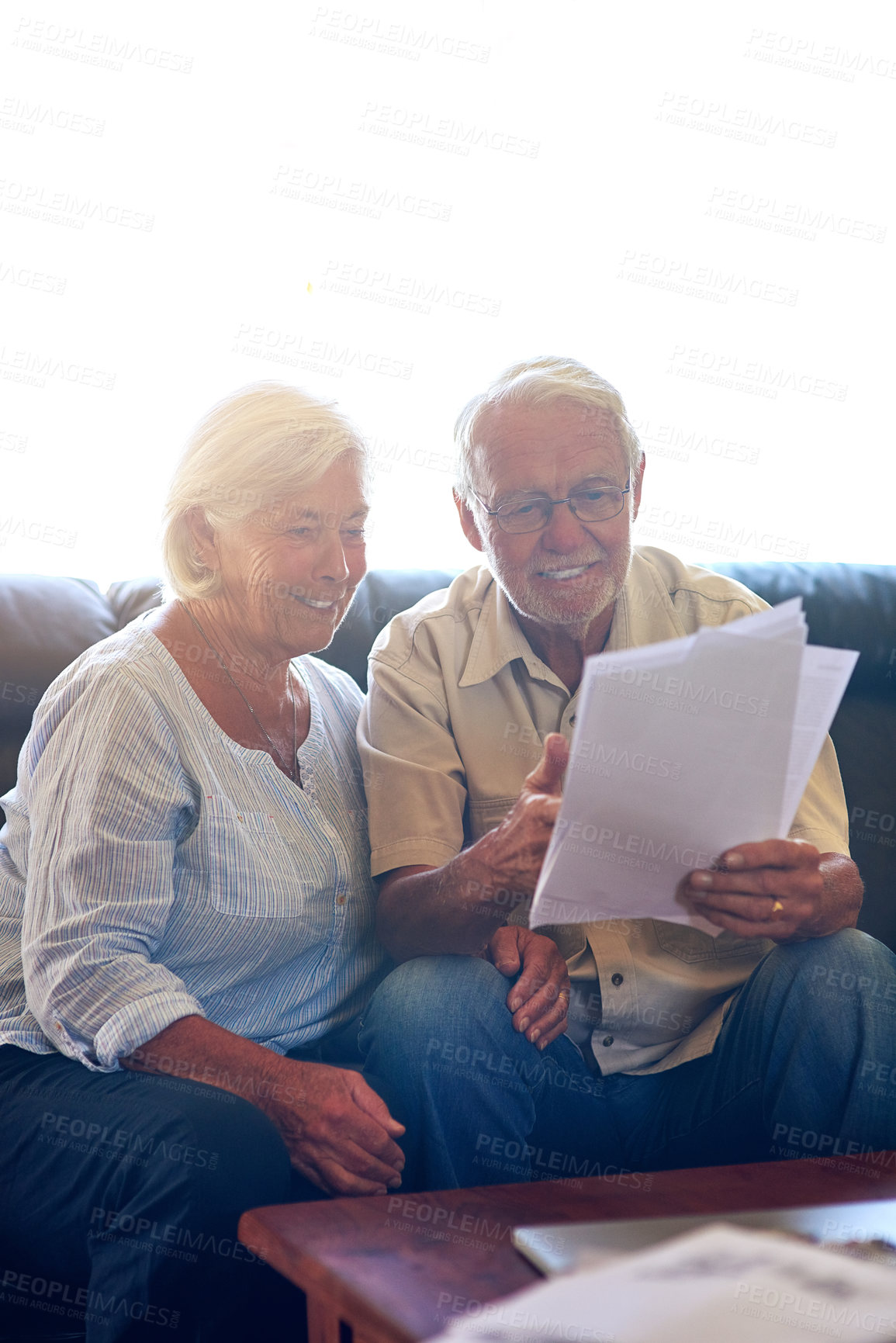 Buy stock photo Shot of a senior couple going through their paperwork together at home