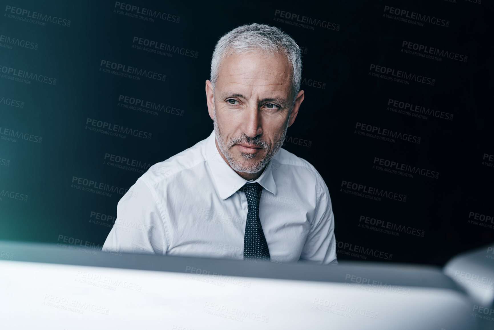 Buy stock photo Shot of a focussed businessman working behind his computer in the office