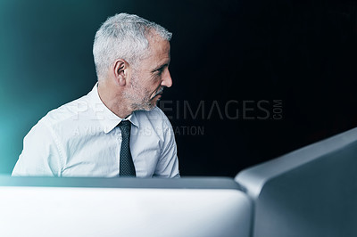 Buy stock photo Shot of a focussed businessman working behind his computer in the office