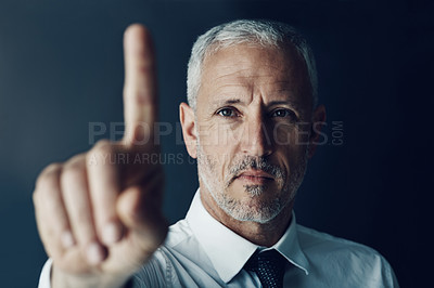 Buy stock photo Portrait of a focussed businessman holding up his finger as if using a touchscreen in the office