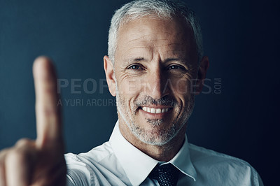 Buy stock photo Shot of a happy businessman holding up his finger as if using a touchscreen in the office