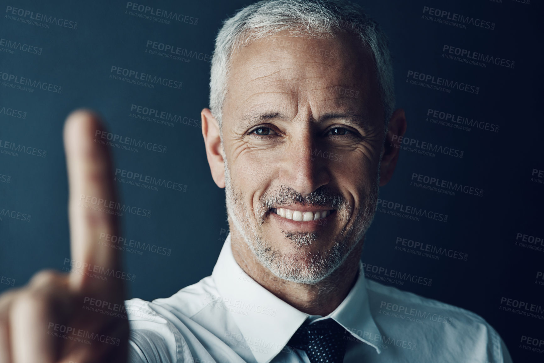 Buy stock photo Shot of a happy businessman holding up his finger as if using a touchscreen in the office