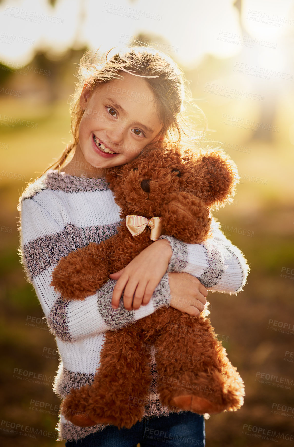 Buy stock photo Portrait of a sweet little girl hugging her teddy bear while playing outside
