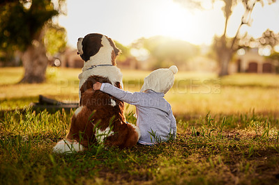 Buy stock photo Rearview shot of a cute little boy hugging his dog while they sit outside