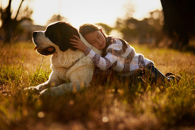 Buy stock photo Shot of a cute little girl cuddling with her dog while they play outside