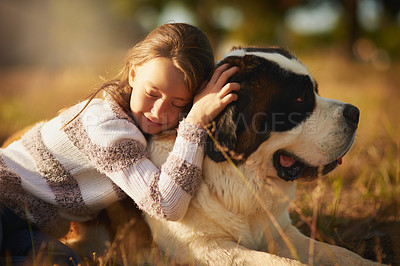 Buy stock photo Shot of a cute little girl cuddling with her dog while they play outside