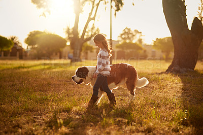 Buy stock photo Shot of a cute little girl walking through a park with her dog