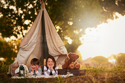 Buy stock photo Portrait of two cute little siblings playing together in a teepee outside