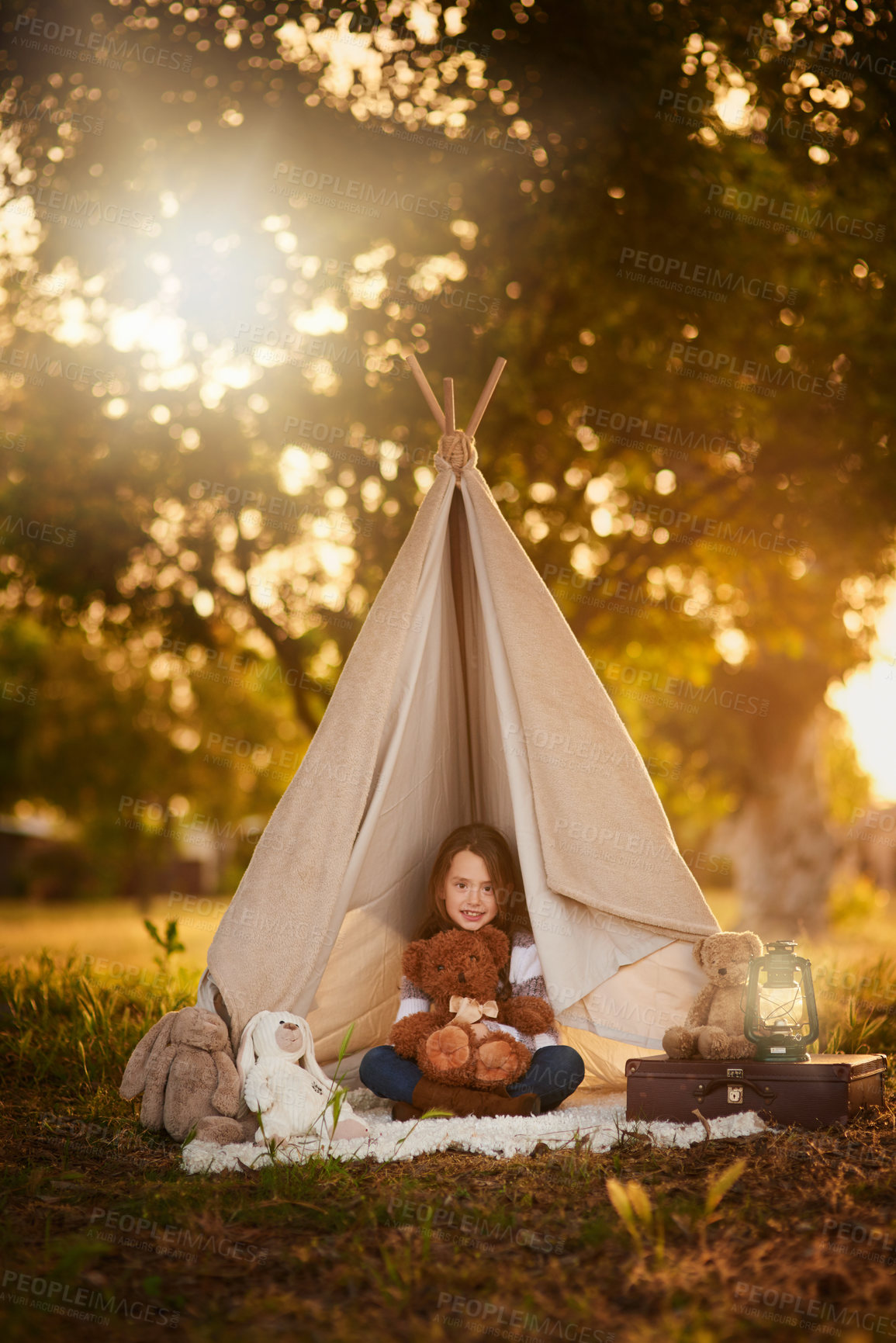 Buy stock photo Teepee, tent and girl with toy in garden outdoor for fun, playing and camping for adventure or imagination. Cloth, shelter and fantasy house for child in forest with blanket, suitcase and teddy bear