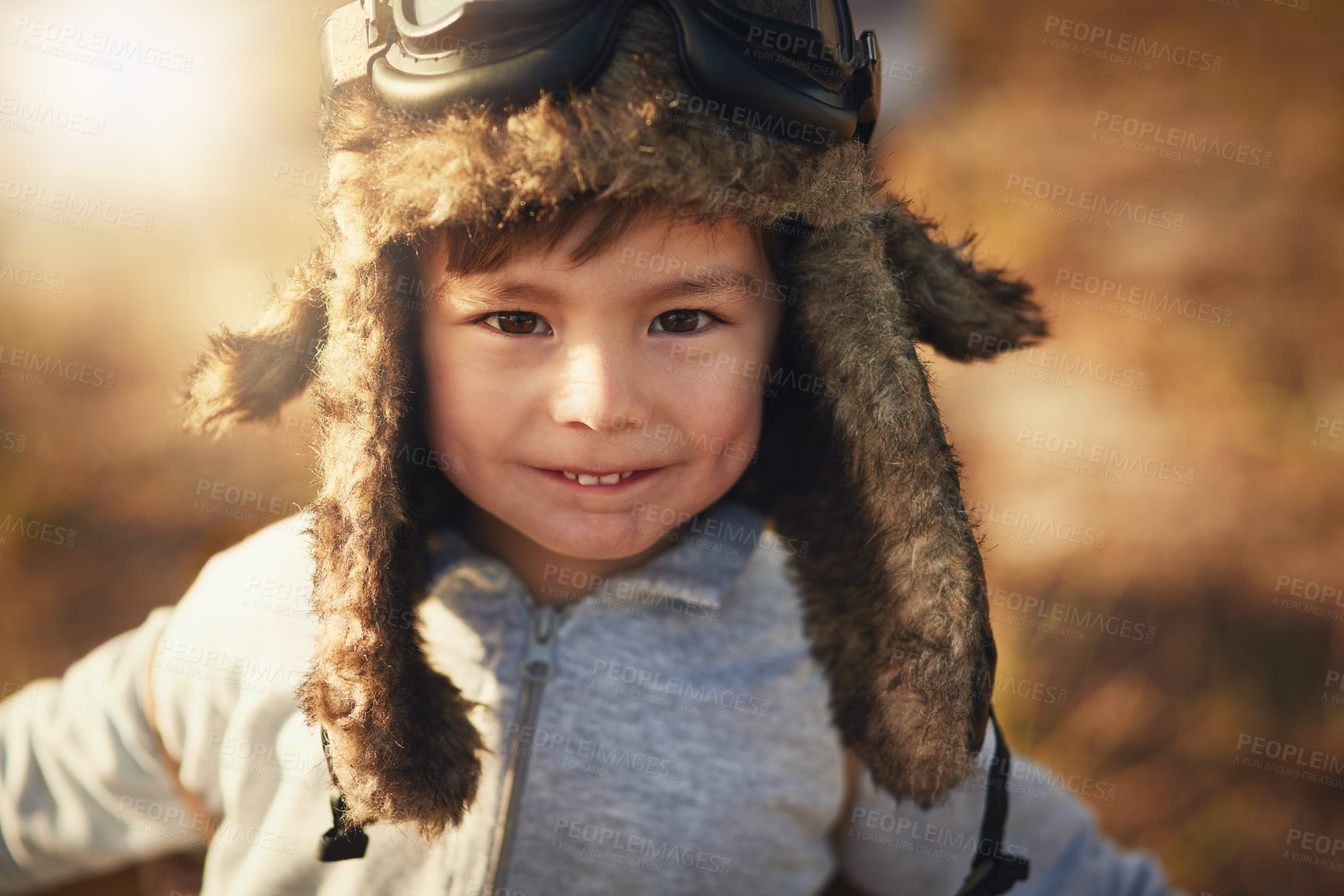 Buy stock photo Portrait of a cute little boy wearing a pilot's hat and goggles while playing outside