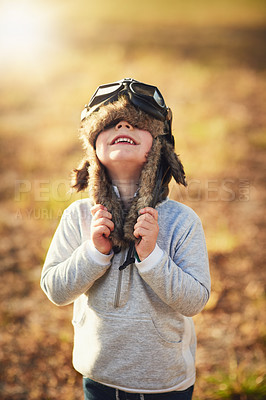 Buy stock photo Shot of a cute little boy wearing a pilot's hat and goggles while playing outside