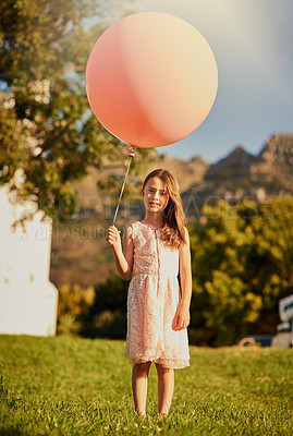 Buy stock photo Portrait of a cute little girl holding a huge balloon while standing outside