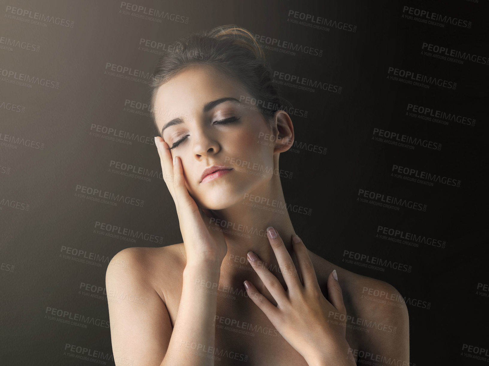 Buy stock photo Studio shot of a beautiful young woman touching her soft skin against a dark background