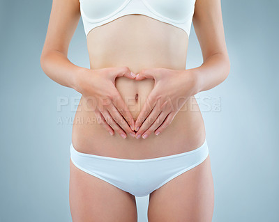 Buy stock photo Woman, hands and stomach for diet in studio on white background with underwear. Female person, isolated and belly or waist with heart icon for self care with gut health, weight loss and wellness