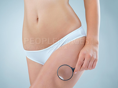 Buy stock photo Woman, magnifying glass and legs in diet, fitness or weight loss against grey studio background. Leg of female inspecting skin in underwear for health, cellulite treatment or body waist results