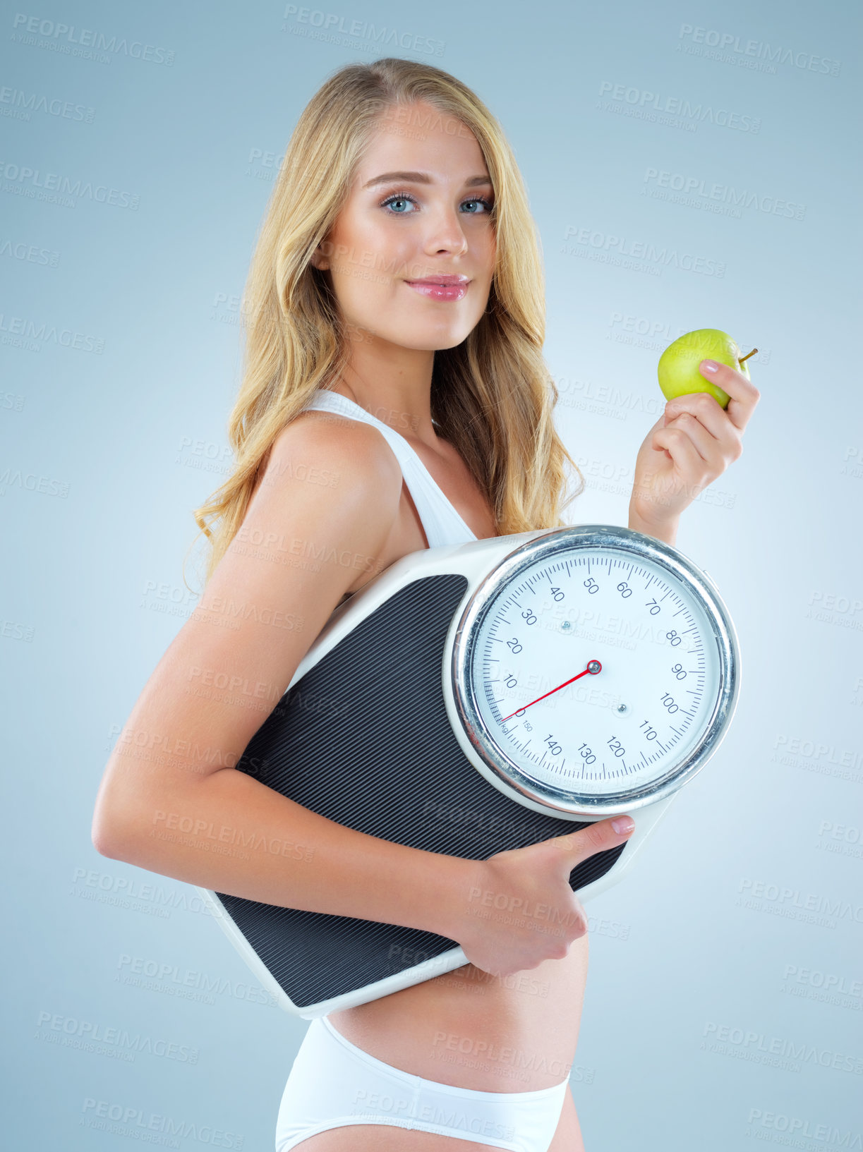 Buy stock photo Woman in portrait, apple with scale and lose weight, smile with healthy food isolated on studio background. Happy female model, health and diet with organic fruit with nutrition and weightloss