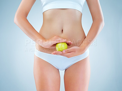 Buy stock photo Person, nutrition and hands with apple in studio for self care slim body or healthy lifestyle on gray background. Fitness, underwear and model with organic fruit for vitamins, diet or lose weight