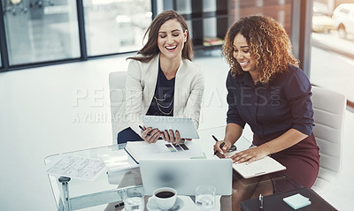 Buy stock photo Shot of two businesswomen discussing something on a digital tablet