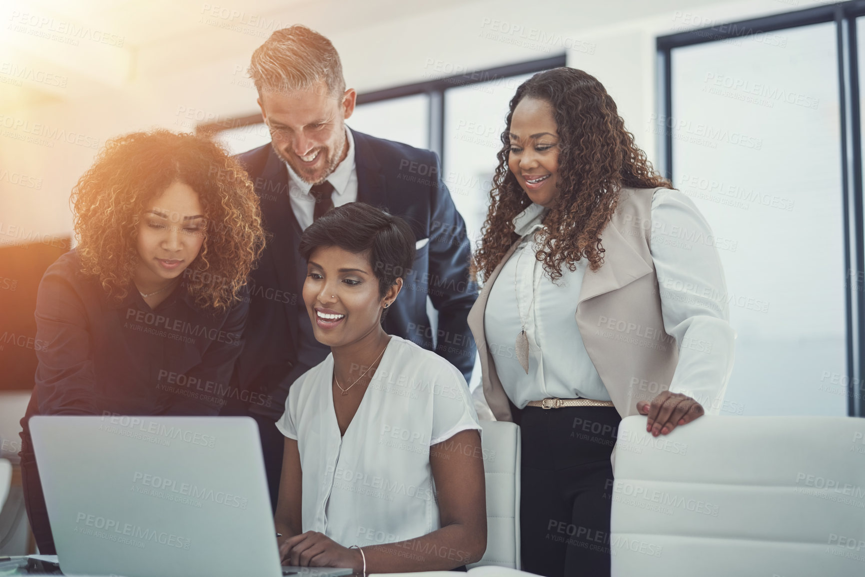 Buy stock photo Shot of a group of colleagues using a laptop together in a modern office