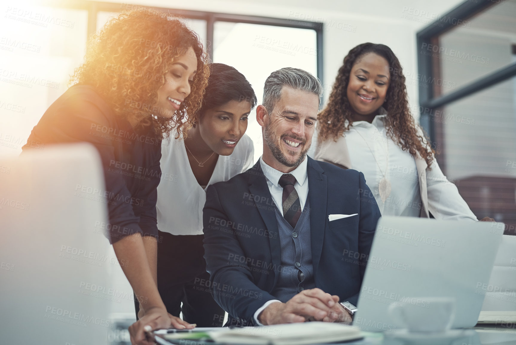 Buy stock photo Shot of a group of colleagues using a laptop together in a modern office