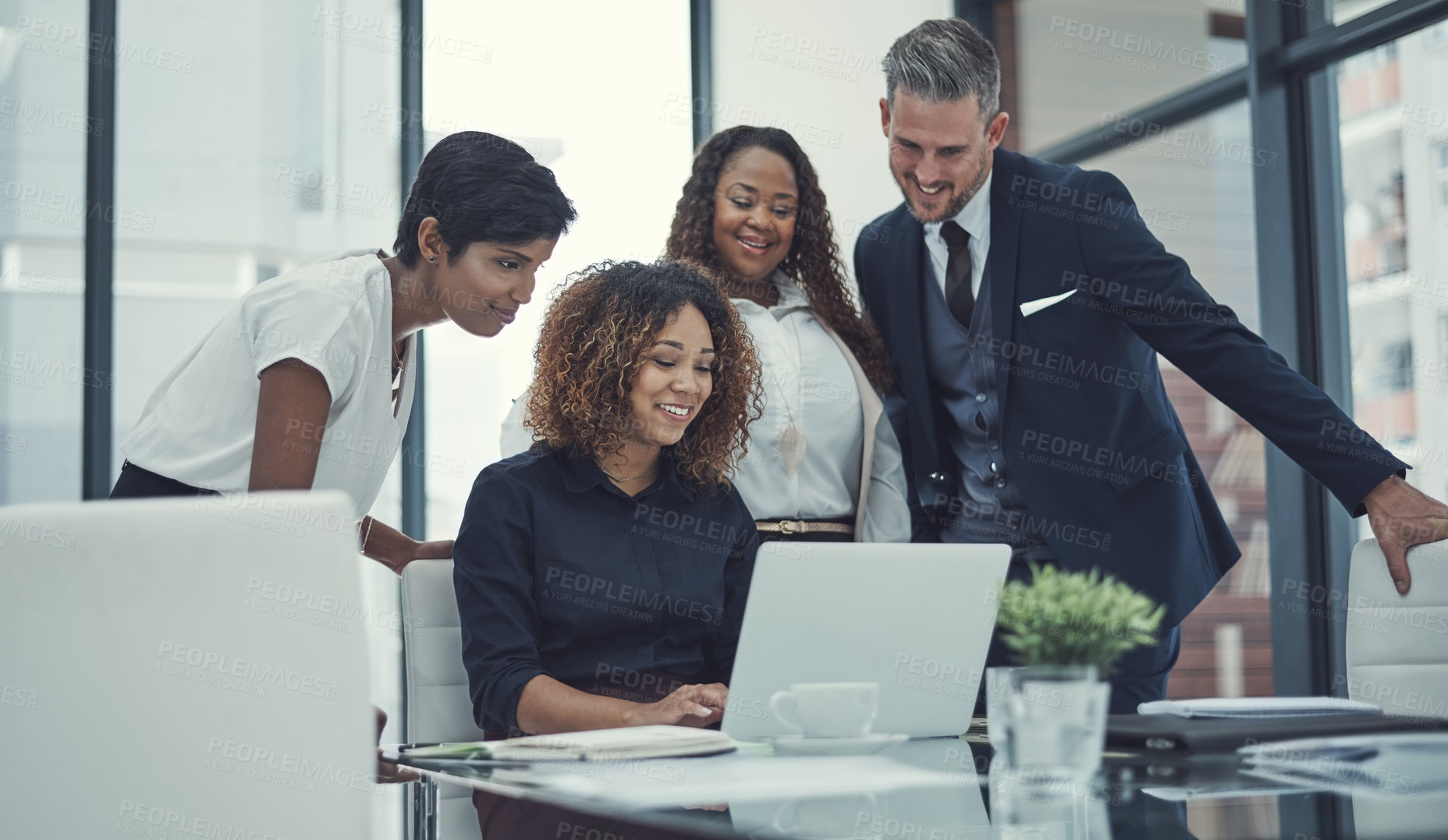 Buy stock photo Shot of a group of colleagues using a laptop together in a modern office