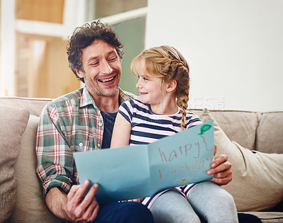 Buy stock photo Cropped shot of a father reading a birthday card made by his little daughter at home