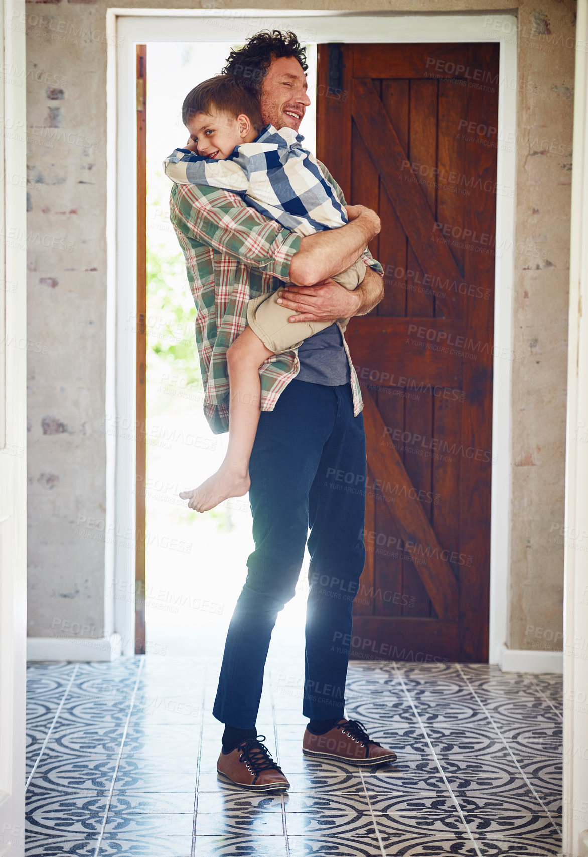 Buy stock photo Boy, father and happy for hugging in house, greeting and caring for relationship bonding with people together. Embrace, love and child development with family home, door and comfort with kid