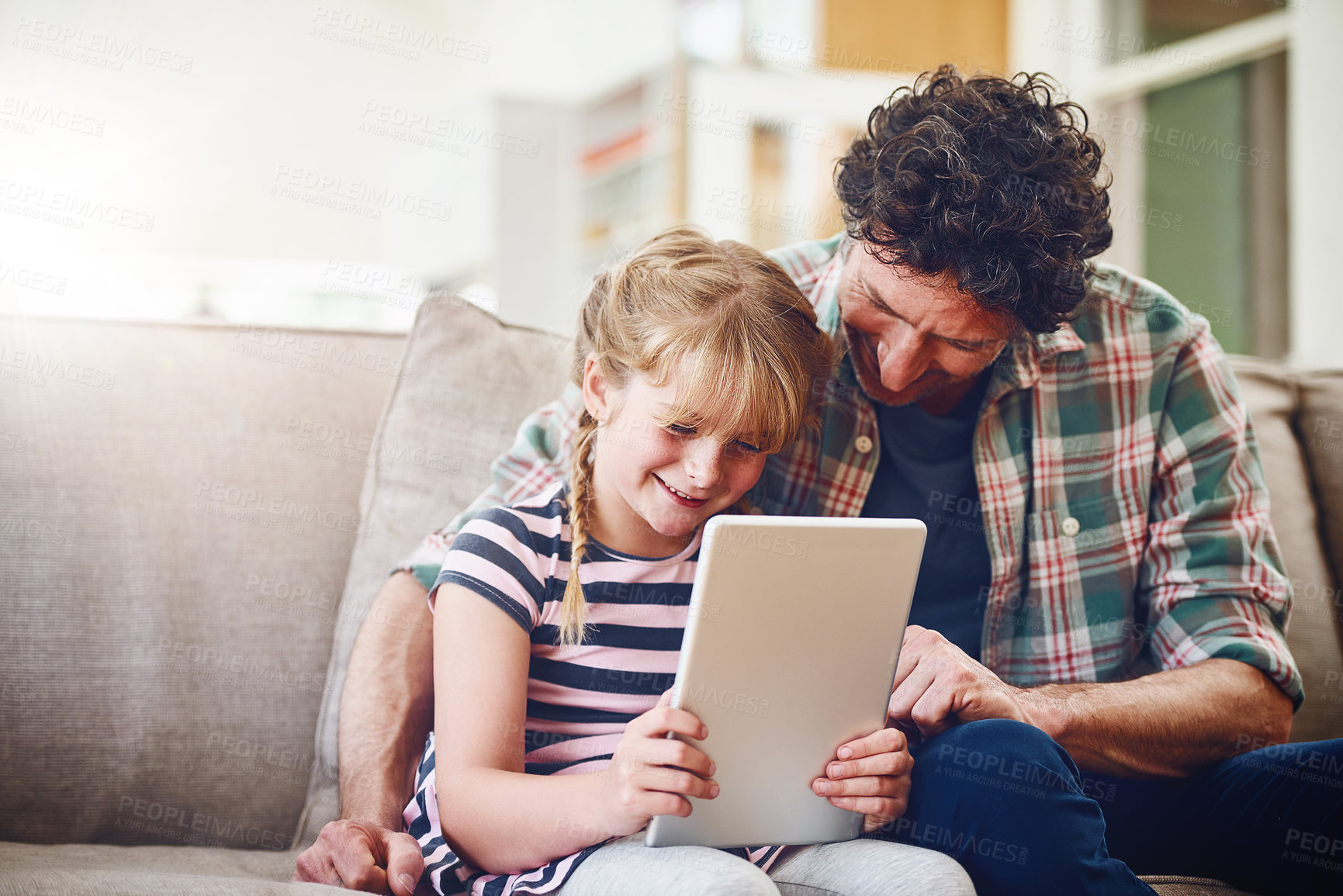 Buy stock photo Home, dad and girl with smile on tablet in sofa for elearning, child development and knowledge with growth. Parent, kid and support with help or teaching for educational game, entertainment or fun