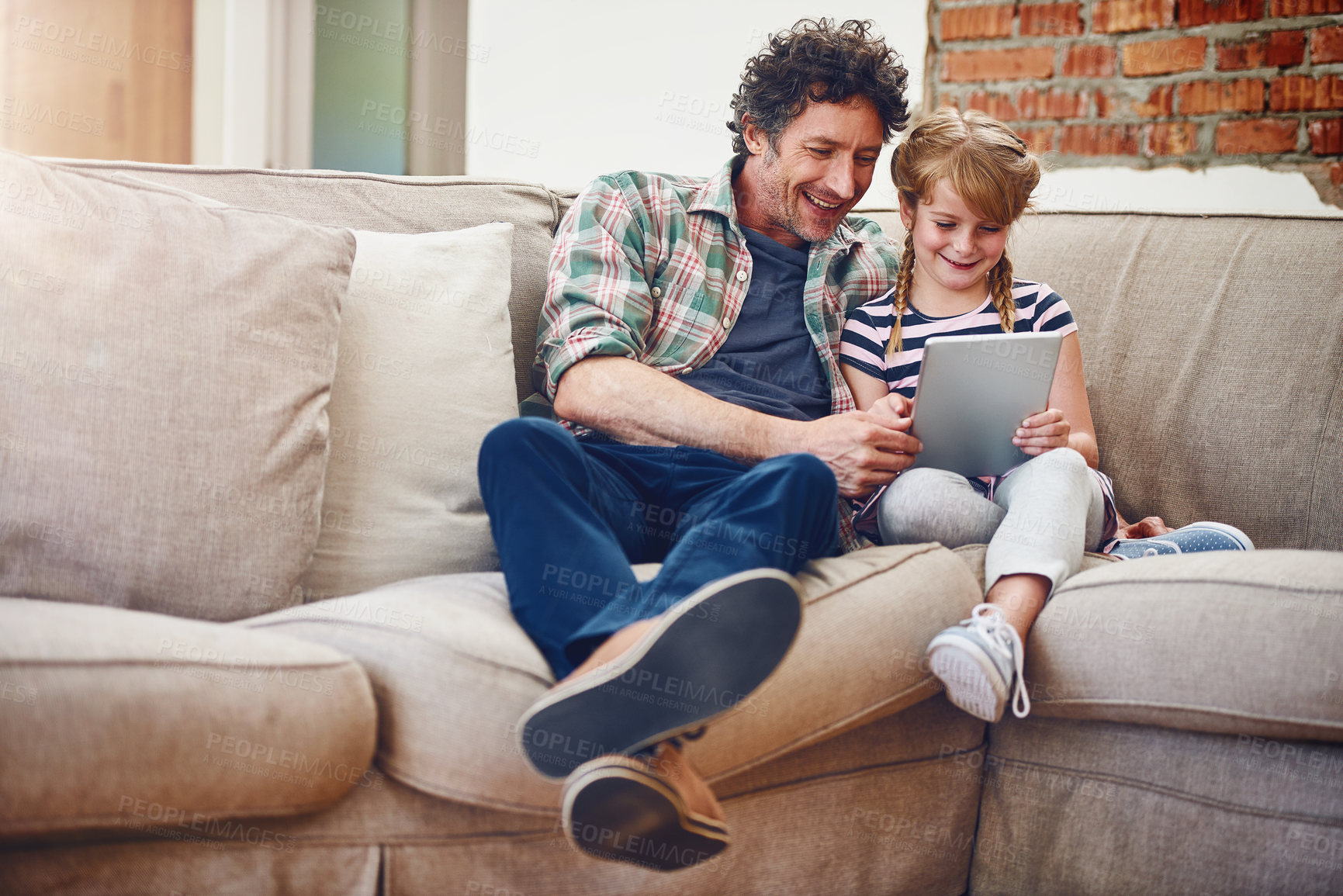 Buy stock photo Happy, dad and girl with tablet in sofa at home for elearning, child development and knowledge with growth. Parent, kid and support with help, teaching and educational games for entertainment or fun