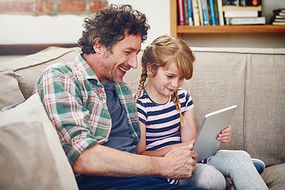 Buy stock photo Cropped shot of a father and his little daughter using a digital tablet at home
