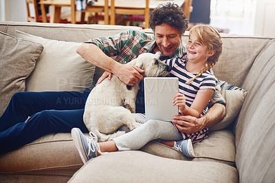 Buy stock photo Cropped shot of a father and his little daughter using a digital tablet at home