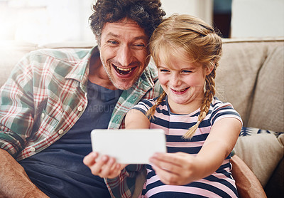 Buy stock photo Happy dad, child and funny face with selfie for picture, photography or memory together at home. Father, daughter or little girl with silly smile for comedy holiday or goofy moment on couch at house