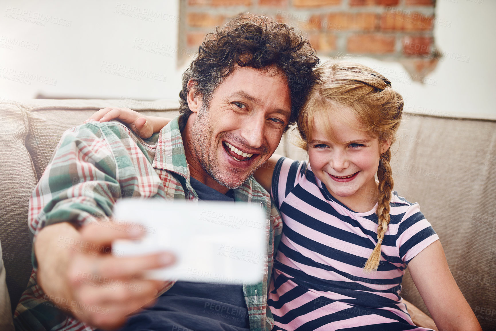 Buy stock photo Happy father, kid and relax with selfie for picture, photography or memory together at home. Dad, daughter or young child with smile for bonding, holiday or weekend moment on lounge couch at house