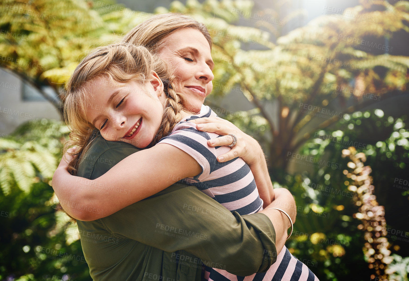 Buy stock photo Cropped shot of a mother hugging her little daughter outside