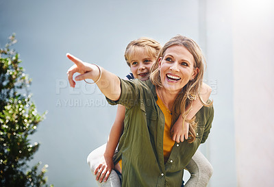 Buy stock photo Happy mother, pointing and piggyback with daughter for bonding, holiday or weekend in backyard at home. Mom, child or little girl with smile for back ride, playing or support for outdoor day together