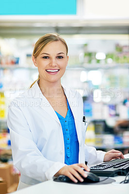 Buy stock photo Shot of a young pharmacist using a computer at the checkout counter
