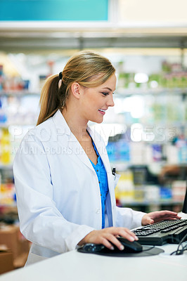 Buy stock photo Shot of a young pharmacist using a computer at the checkout counter
