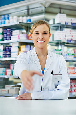 Buy stock photo Portrait of a happy young pharmacist extending her arm for a handshake