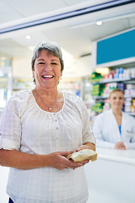Buy stock photo Portrait of a happy mature woman buying medication at a pharmacy