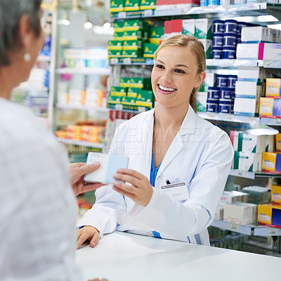Buy stock photo Shot of a young pharmacist assisting a customer