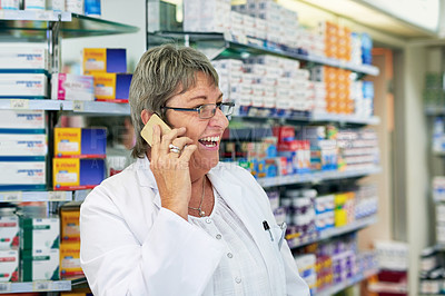 Buy stock photo Shot of a mature pharmacist talking on a cellphone in a chemist