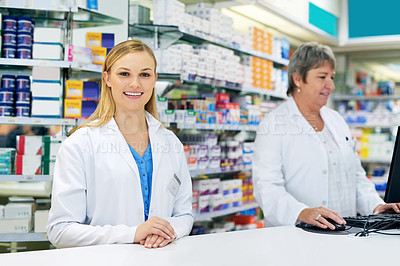 Buy stock photo Portrait of a happy young woman in a pharmacy alongside her coworker