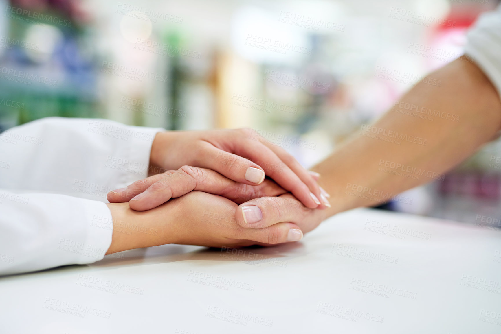 Buy stock photo Cropped shot of a pharmacist  compassionately holding a customer’s hand