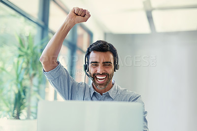 Buy stock photo Cropped shot of a call centre agent doing a fist pump while working on a laptop in an office