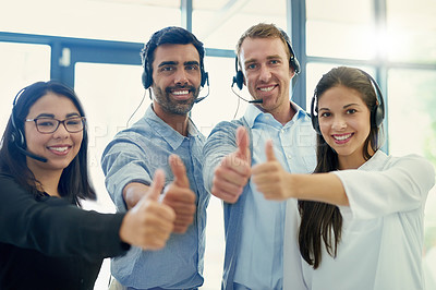 Buy stock photo Portrait of a team of call centre agents showing thumbs up together in an office