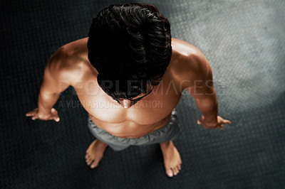 Buy stock photo High angle shot of a muscular young man standing on a gray floor