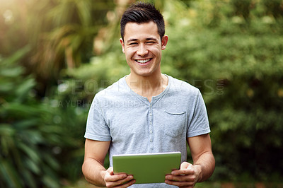 Buy stock photo Portrait of a handsome young man using a digital tablet outside