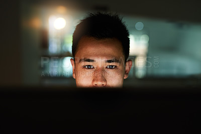 Buy stock photo Shot of a handsome young male programmer working late in his office
